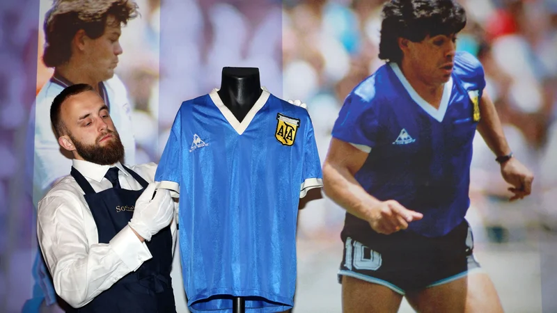 Fotografija: Prizor z dražbe, na kateri se je eden najslavnejših nogometnih predmetov vseh časov znašel po zaslugi Steva Hodgea, angleškega vezista, ki si je po tekmi v Mexico Cityju leta 1986 izmenjal dres z Maradono. FOTO: Adrian Dennis/AFP