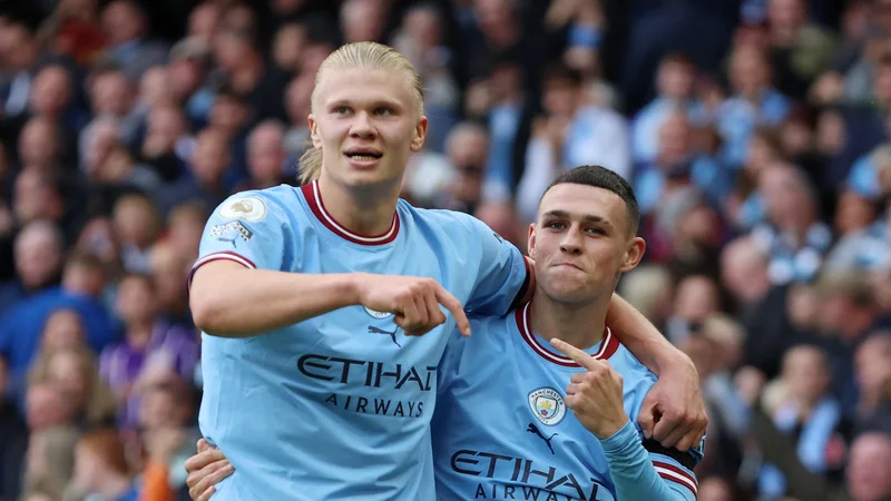 Phil Foden (desno) in Erling Haaland sta tekmovala, kdo bo večrat premagal vratarja Uniteda. FOTO: Phil Noble/Reuters
