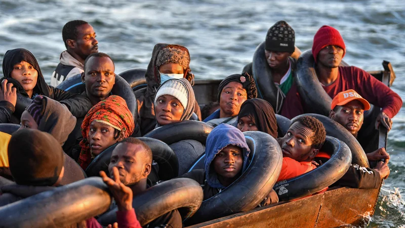 Fotografija: Migranti iz podsaharske Afrike sedijo v doma narejenem čolnu, s katerim so se skrivaj prebijali proti italijanski obali, ko so jih tunizijske oblasti našle ob obali osrednjega tunizijskega mesta Sfax, približno 50 navtičnih milj. Foto: Fethi Belaid/Afp