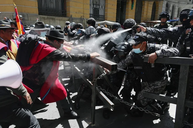 Avtohtoni kmetje iz province Omasuyos v bolivijskem višavju, imenovanI »Ponchos Rojos« so se po pohodu iz mesta El Alto na sedež vlade v La Pazu spopadli s policijo. Od vlade zahtevajo izpolnitev obljub za njihov sektor. Rdeči ponči so politični zavezniki vladajoče stranke Movimiento Al Socialismo. Foto: Aizar Raldes Afp