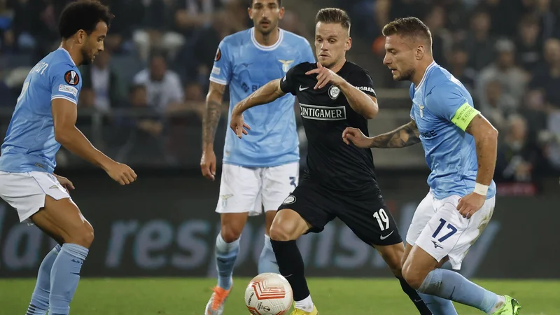 Fotografija: Tomi Horvat (v črnem) je bil takole okrožen s tremi nogometaši Lazia, nemočen je bil tudi odlični napadalec Ciro Immobile. FOTO: Erwin Scheriau/AFP