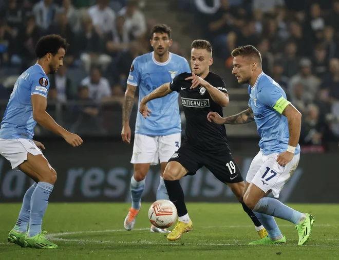 Tomi Horvat (v črnem) je bil takole okrožen s tremi nogometaši Lazia, nemočen je bil tudi odlični napadalec Ciro Immobile. FOTO: Erwin Scheriau/AFP
