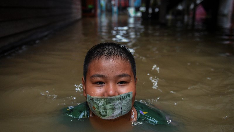 Fotografija: Tajski deček se igra na poplavljeni cesti po obilnem deževju v bližini mošeje Tha-it na obrobju Bangkoka. Foto: Chalinee Thirasupa/Reuters
