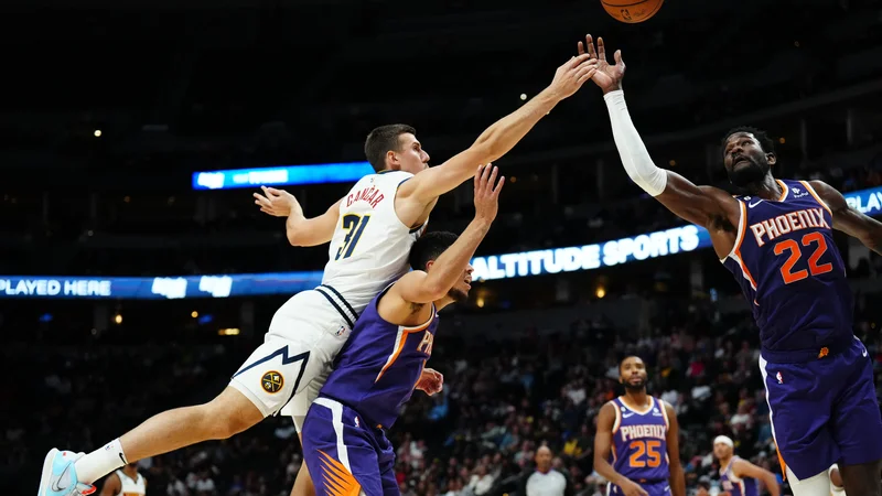 Slovenski reprezentant Vlatko Čančar je imel v davišnji pripravljalni košarkarski tekmi pred začetkom lige NBA proti Deandreju Aytonu (22) in Devinu Bookerju zelo soliden strelski izkupiček. FOTO: Ron Chenoy/Usa Today Sports