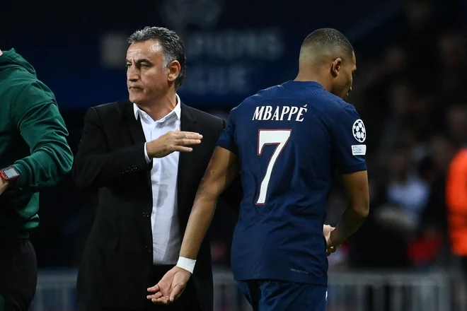 Kylian Mbappe ob trenerju Christophu Galtierju po menjavi v drugem polčasu tekme z Benfico. FOTO: Franck Fife/AFP
