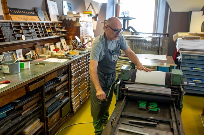 Valj tiskarskega stroja lepo zdrsne čez črke, tokrat pobarvane z zeleno. FOTO: Voranc Vogel/Delo
