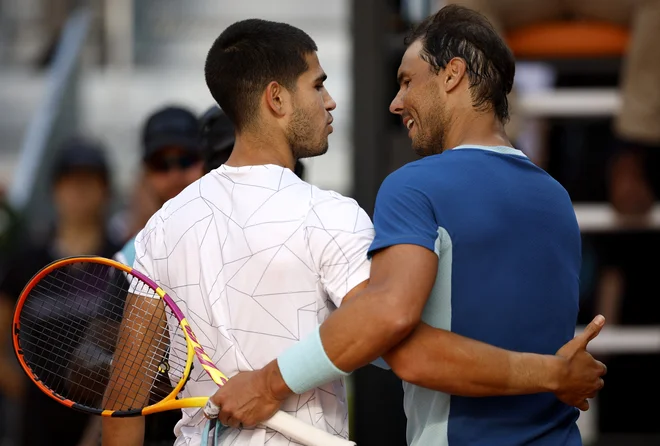 Carlos Alcaraz (levo) in Rafael Nadal po letošnjem spopadu v Madridu, kjer se je v četrtfinalu turnirja serije masters 1000 zmage s 6:2, 1:6 in 6:3 veselil Alcaraz. FOTO: Juan Medina/Reuters