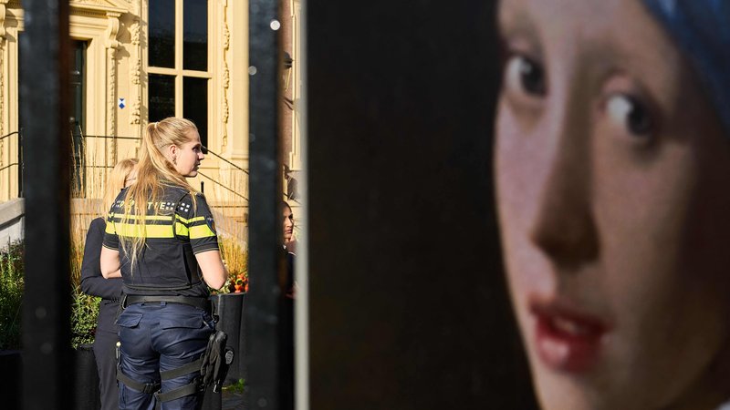 Fotografija: Policistka pred muzeju v Haagu, kjer so aktivisti Just Stop Oil napadli sliko Dekle z bisernim uhanom. FOTO: Phil Nijhuis/AFP
