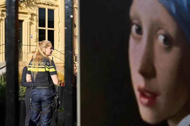 Policistka pred muzeju v Haagu, kjer so aktivisti Just Stop Oil napadli sliko Dekle z bisernim uhanom. FOTO: Phil Nijhuis/AFP