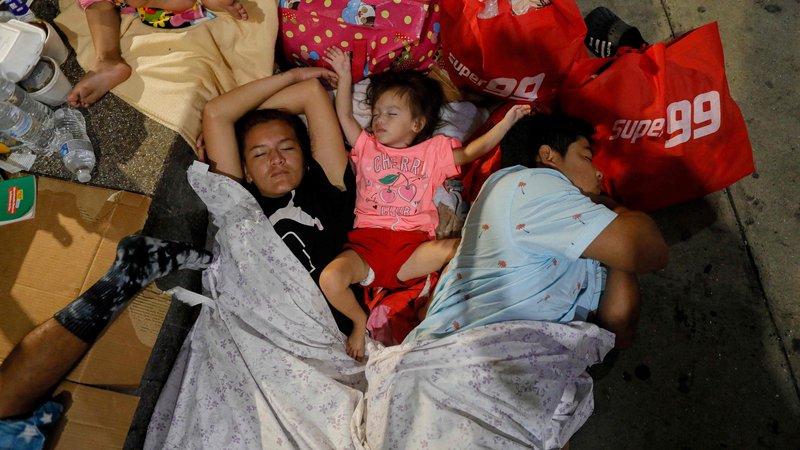 Fotografija: Migrantska družina iz Venezuele, ki ji ni uspelo prebegniti v ZDA, spi na tleh avtobusne postaje v glavnem mestu Paname, Panama Cityju. FOTO: Roberto Cisneros/Afp

