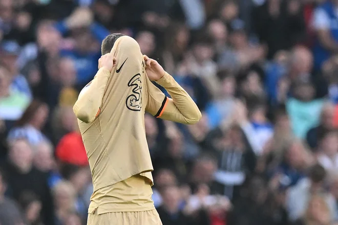 Chelseajevi nogometaši so od sramu zaradi poraza v Brightonu skrili obraz. FOTO: Glyn Kirk/AFP
