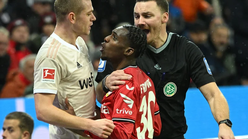 Fotografija: Nizozemski branilec Jeremie Frimpong (v sredini) se je v Leverkusnu pomeril z gostujočim kolegom iz obrambe, Norvežanom Julianom Ryersonom. FOTO: Ina Fassbender/AFP
