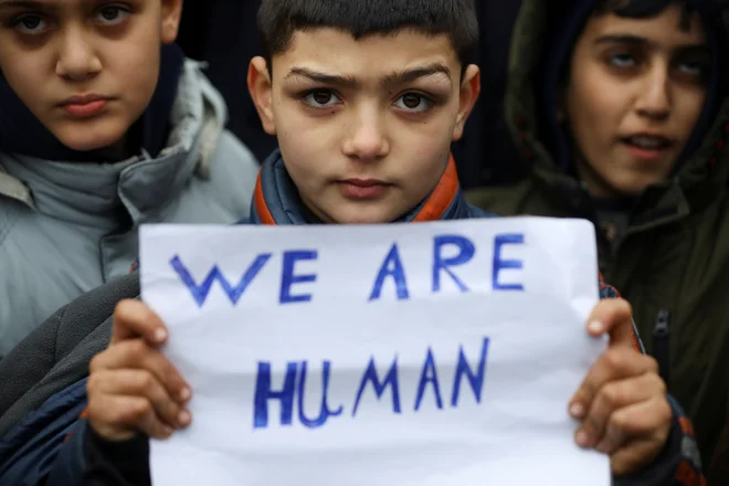 Otroci migrantov držijo napis med protestom pred transportno-logističnim centrom Bruzgi na belorusko-poljski meji. Foto: Kacper Pempel/Reuters