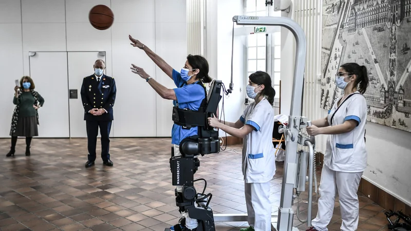 Fotografija: V bolnišnici Invalides v Parizu med demonstracijo pacient preizkuša eksoskelet. Foto: Stephane De Sakutin/Afp