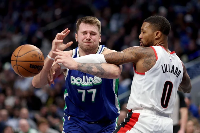 Luko Dončića (na fotografiji ga ovira Damian Lillard) so poskušali ustaviti na vse mogoče načine. FOTO: Tom Pennington/AFP

