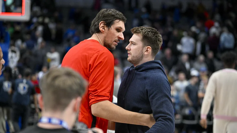 Fotografija: Luka Dončić si je dvoboj proti Houstonu odgledal s kloopi za rezervne igrlace in se prisrčno pozdravil s svojim nekdanjim soigralcem in prijateljem Bobanom Marjanovićem. FOTO: Jerome Miron/Usa Today Sports
