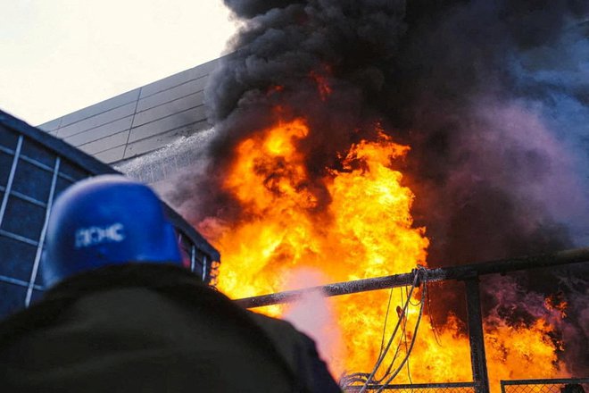 Gasilci poskušajo pogasiti požar v termoelektrarni, ki ga je povzročila ruska raketa. FOTO: Reuters
