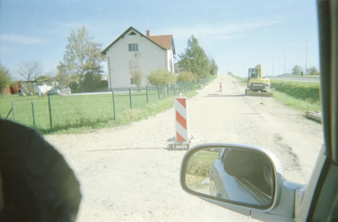 To ni le fotografija nezgrajene ceste, ampak tudi delni avtoportret z roko v ogledalu. FOTO: Sandi Sendelbah
