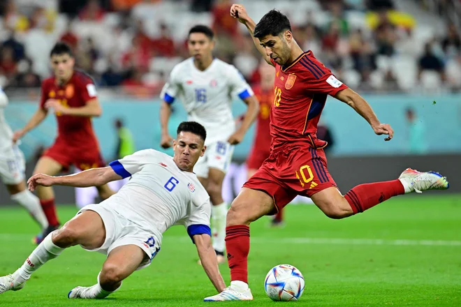 Marco Asensio je po podaji branilca Jordija Albe matiral nekdanjega klubskega soigralca Keylorja Navasa. FOTO: Javier Soriano/AFP
