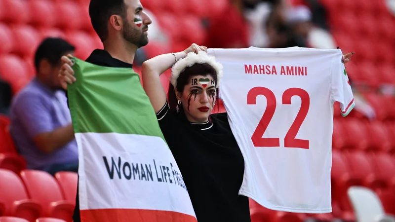 Fotografija: Na tribunah je več deset iranskih navijačev nosilo majice z napisom »Zan, Zindagi, Azadi« (»Ženske, življenje, svoboda«), pred stadionom pa jih je prav toliko vzklikalo: »Izgovori njeno ime, Mahsa Amini.« FOTO: Dylan Martinez/Reuters