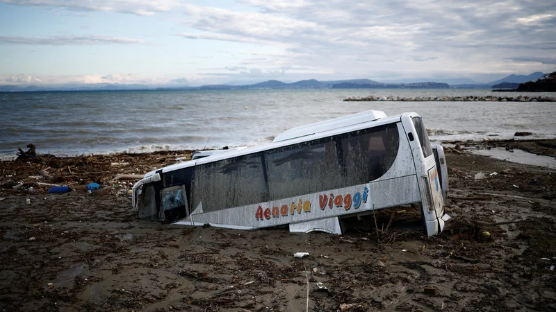 Fotografija: Avtobus v blatu ob morju. FOTO: Guglielmo Mangiapane/Reuters