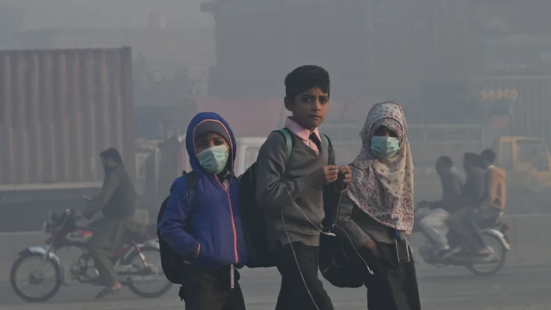 Fotografija: Afganistanski otroci hodijo v šolo med hudim smogom v Lahoreju. Foto: Arif Ali/Afp
