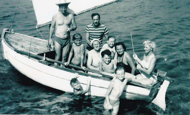 Dušan Puh (s slamnikom, stoji v pasari Vida) je poleti 1960 pogosto iz Portoroža z družino prijadral do Kanegre.
Poleg njega se na veslo naslanja hči Irena, pri krmilu je pokojna žena Etelka, v morju pa sta ob čolnu mladi Dušan in hči Jelka. FOTO: družinski arhiv
