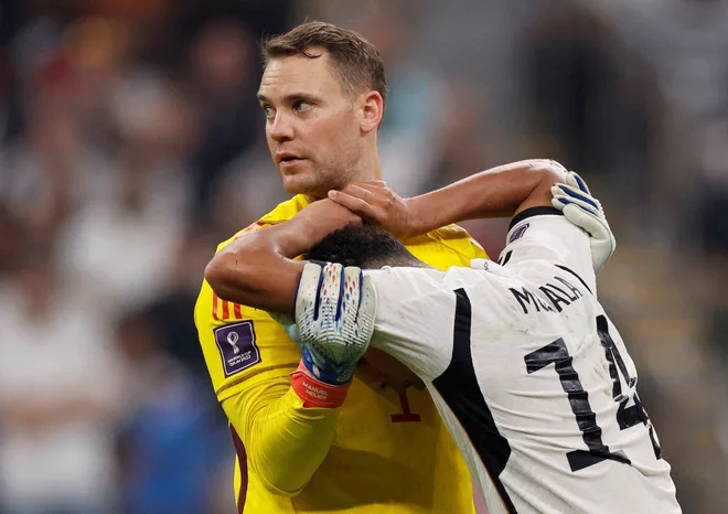 Manuel Neuer tolaži klubskega soigralca Jamala Musialo. FOTO: Thaier Al-Sudani/Reuters
