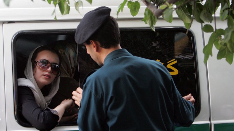 Fotografija: Pripadnik iranske moralne policije v akciji. Foto Behrouz Mehri/AFP
