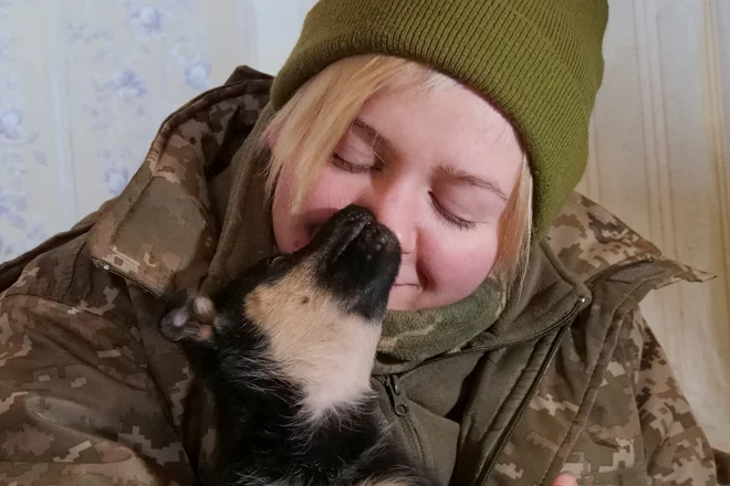 Ukrajinska vojakinja, 28-letna Valerija, drži enega od dveh kužkov, ki so ju pred dvema tednoma našli v zapuščeni hiši na frontni črti v bližini mesta Bakhmut v regiji Doneck. Foto: Stringer/Reuters