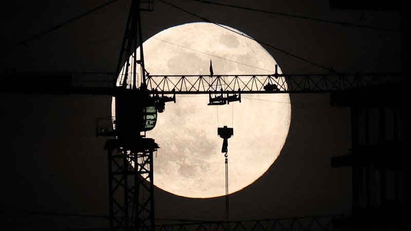 Fotografija: Zadnja polna luna v tem letu, znana kot mrzla luna, vzhaja za gradbiščem v Ankari. Foto: Adem Altan/Afp
