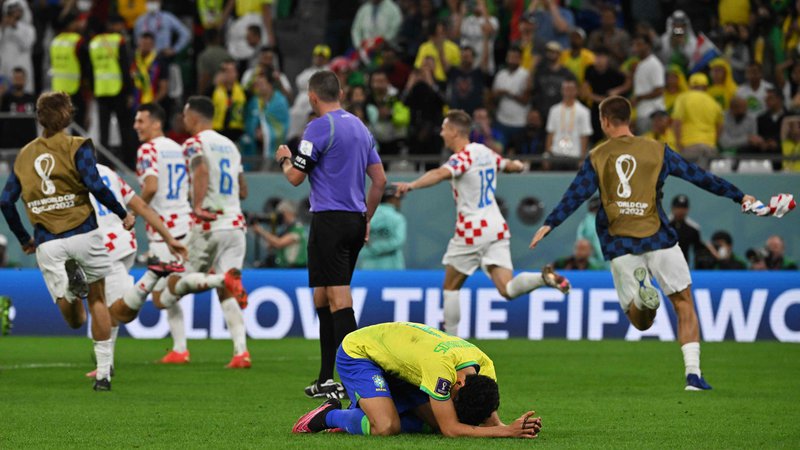 Fotografija: Hrvaški nogometaši slavijo, brazilski branilec Marquinhos pa je obležal na zelenici. FOTO: Nelson Almeida/AFP
