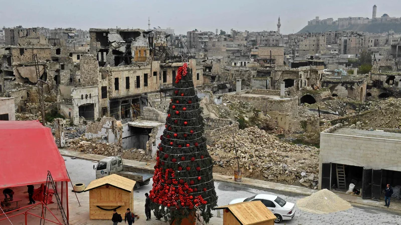 Fotografija: Delavci postavljajo božično drevo na trgu al-Hatab v severnem sirskem mestu Alep. Foto: Afp