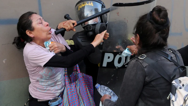 Fotografija: Ženski se upirata policistu med protestom v Limi, na katerem zahtevajo razpustitev kongresa in demokratične volitve, ne pa priznanje Dine Boluarte za novo predsednico Peruja po odstavitvi perujskega predsednika Pedra Castilla. FOTO: Sebastian Castaneda/Reuters