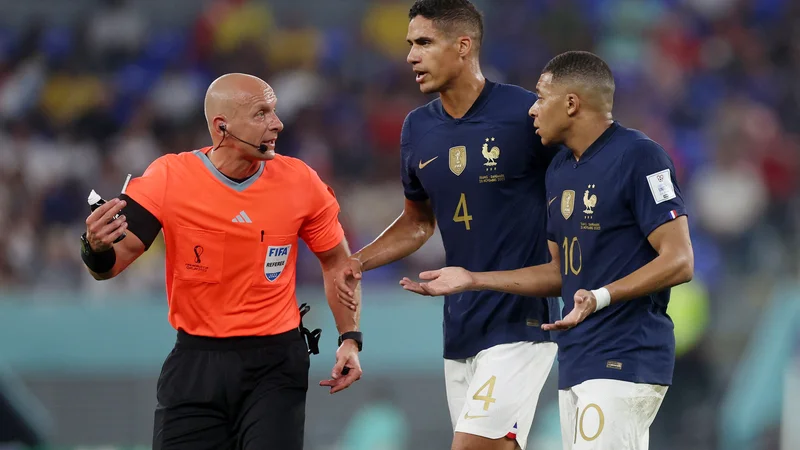 Fotografija: Szymon Marciniak je že zaznamoval letošnji mundial, takole sta imela z njim opraviti tudi Raphael Varane in Kylian Mbappe. FOTO: Lee Smith/Reuters
