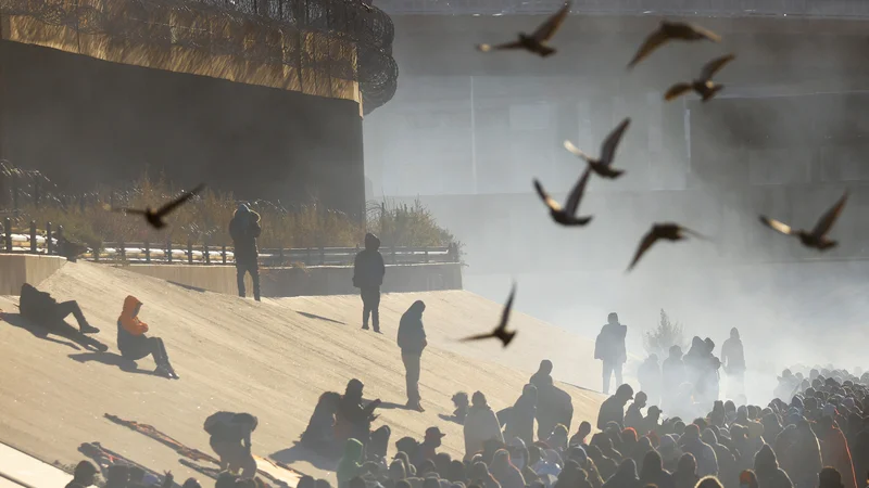 Fotografija: Migranti čakajo v vrsti pri mejnem zidu, potem ko so prečkali reko Rio Bravo, da bi se predali agentom ameriške mejne patrulje in zaprosili za azil v ameriškem mestu El Paso v Teksasu. Foto: Jose Luis Gonzalez/Reuters