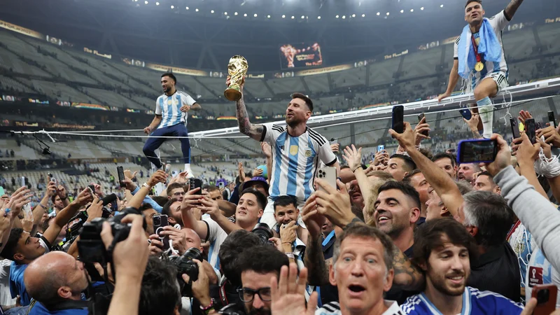 Fotografija: Lionel Messi je 35 let živel za ta trenutek: takole se je po zmagi v finalu mundiala pridružil rojakom pred njihovo tribuno. FOTO: Carl Recine/Reuters