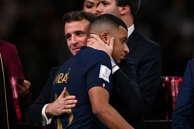 Emmanuel Macron in Kylian Mbappe med podelitvijo nagrad na zelenici štadiona v Lusailu po koncu finalnega obračuna med Argentino in Francijo. FOTO:&nbsp;Kirill Kudrjavcev/AFP
