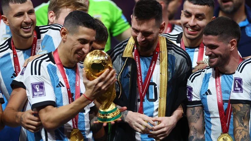 Fotografija: Na odru za zmagovalce je Lionel Messi kot prvemu izmed soigralcev pokal predal ravno Angelu Di Marii. FOTO: Kai Pfaffenbach/Reuters