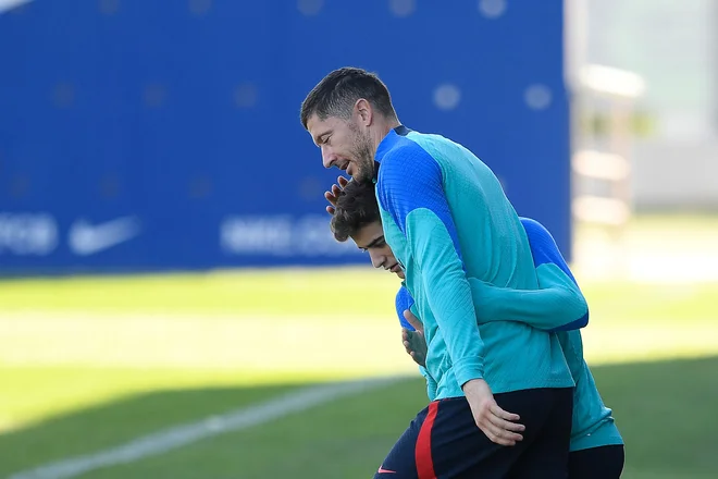 Robert Lewandowski ob španskem reprezentantu Gaviju na začetku petkovega treninga v klubskem centru Joan Gamper na skrajnem zahodu Barcelone.&nbsp;FOTO: Josep Lago/AFP
