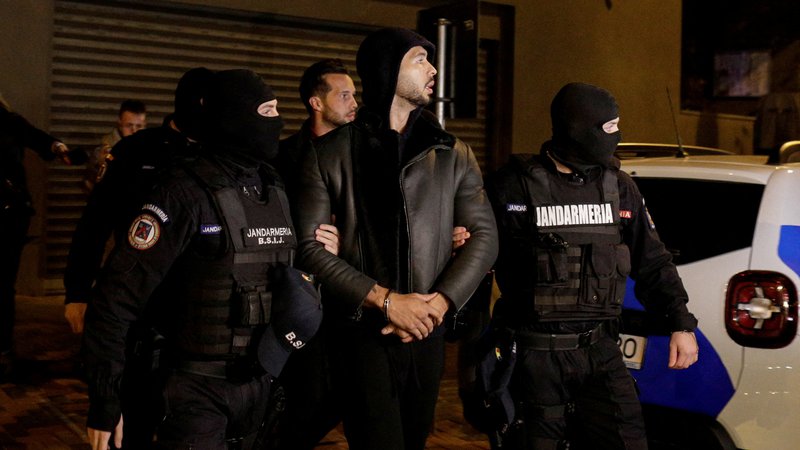 Fotografija: Andrew Tate in Tristan Tate pred njuno vilo med aretacijo v Bukarešti. Osumljena sta trgovine z ljudmi, izkoriščanja žensk ter posilstva. FOTO: Reuters
