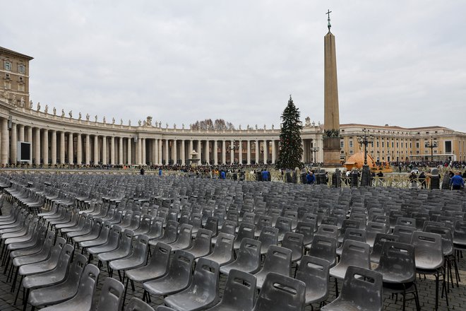 Na Trgu svetega Petra je postavljen oltar za mašo, pripravljeni so tudi stoli za vernike in več velikih platen, na katerih bodo lahko spremljali pogrebne slovesnosti. FOTO: Kai Pfaffenbach/Reuters
