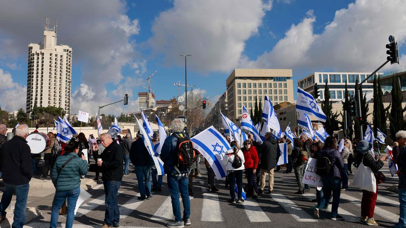 Fotografija: Protest pred izraelskim vrhovnim sodiščem, kjer je ta teden potekala razprava o tem, ali lahko v Netanjuhujevem kabinetu služi tudi eden od njegovih tesnih zaveznikov, ki je bil lani obsojen zaradi davčne utaje. Foto: Menahem Kahana/AFP
