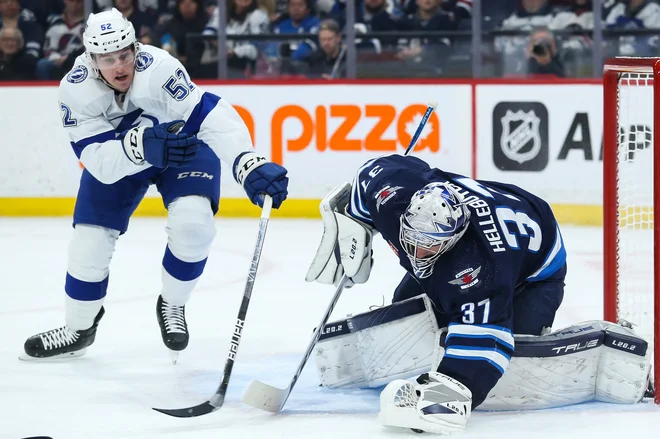 Connor Hellebuyck ustavlja napad branilca Tampe Cala Foota v prvi tretjini dvoboja, ki ga je gostila dvorana Canada Life Centre. FOTO: Terrence Lee/USA Today Sports