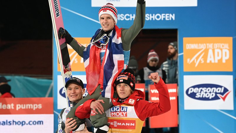 Fotografija: Anže Lanišek (levo) in Dawid Kubacki (desno) sta po tekmi v Bischofshofnu dvignala na rame zmagovalca novoletne turneje Halvorja Egnerja Graneruda. FOTO: Christof Stache/AFP
