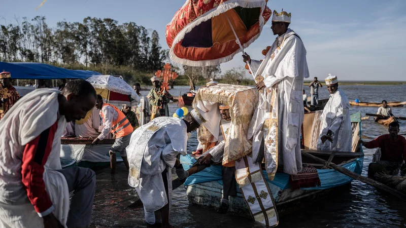 Fotografija: Visoki duhovniki si sezujejo čevlje, ko se s skrinjo zaveze pripeljejo na obalo in praznujejo timkat (etiopsko epifanijo) na jezeru Batu v Etiopiji. Foto: Amanuel Sileshi/Afp