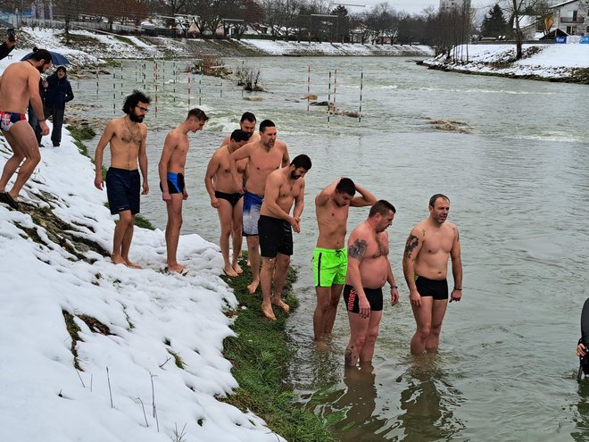 Počasi so stopali v mrzlo Savinjo in tokrat drug za drugim zaplavali proti križu. FOTO: Špela Kuralt/Delo
