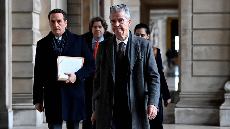 Fotografija: Belgijski odvetnik Eve Kaili Andre Risopoulos (in njegov grški kolega Michalis Dimitrakopoulos stopata pred novinarje. FOTO: John Thys/Afp