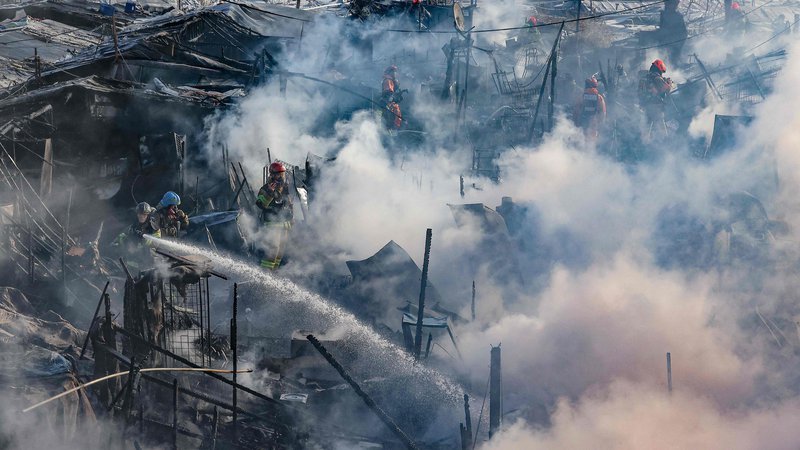 Fotografija: Gasilci poskušajo pogasiti požar v eni zadnjih revnih četrti Seula. Okoli 500 ljudi je moralo zapustiti svoje domove, potem ko je izbruhnil požar v slumu, sestavljenem iz nelicenciranih stanovanj, ki se nahaja v bogatem okrožju Gangnam. Foto: Afp
