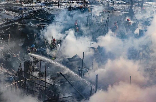 Gasilci poskušajo pogasiti požar v eni zadnjih revnih četrti Seula. Okoli 500 ljudi je moralo zapustiti svoje domove, potem ko je izbruhnil požar v slumu, sestavljenem iz nelicenciranih stanovanj, ki se nahaja v bogatem okrožju Gangnam. Foto: Afp
